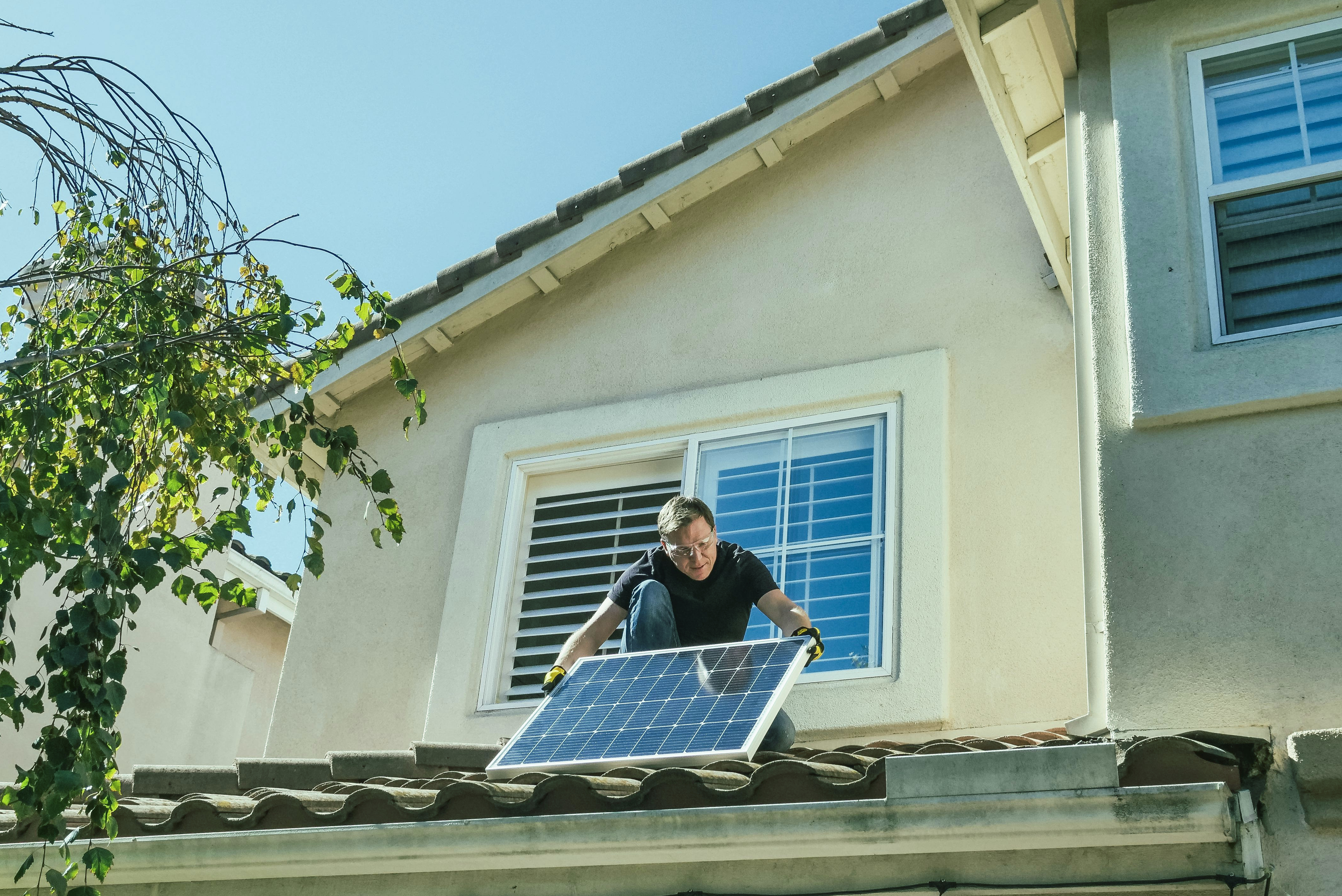 Solar panel installation in progress on a large roof